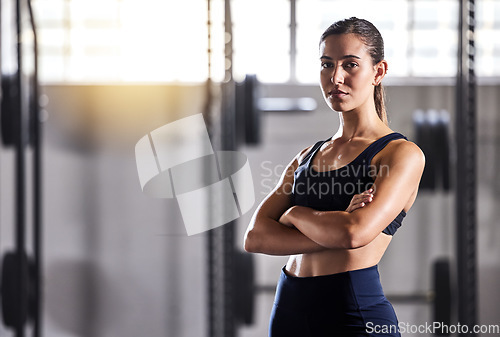 Image of Fit, slim and serious woman with arms crossed, feeling confident about her body and health while standing in gym. Portrait of a sporty and determined woman ready to exercise to stay in healthy shape