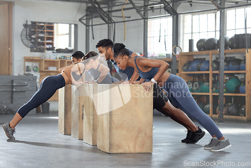 Image of Group training, incline push up and bodyweight exercise, workout and fitness in a gym class with plyometric jump boxes. Sporty, strong and active people with endurance, energy and wellness challenge