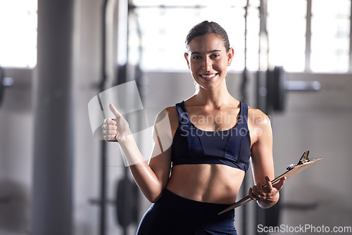 Image of Thumbs up, personal trainer and fitness coach with gym clipboard to monitor health, weight loss and muscle growth. Portrait of excited woman and fit athlete supporting exercise, workout and training