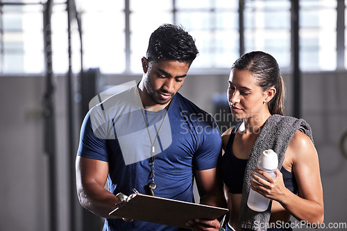 Image of Coach planning workout, schedule and training with athlete for active, fitness and wellness in a gym. Trainer writing notes for sports client with routine to gain toned, strong and fit body muscle