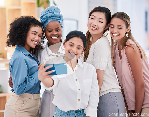 Image of Diverse fun business friends taking selfies on a phone together in an office. Happy and beautiful colleagues or friends smiling for photos and posing as an ambitious team in a startup agency