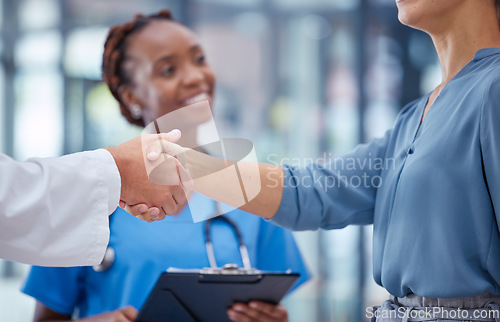 Image of Doctors handshake thank you, greeting or good medical breakthrough success with smiling nurse in background. Physician, healthcare worker and patient shaking hands for innovation in health research