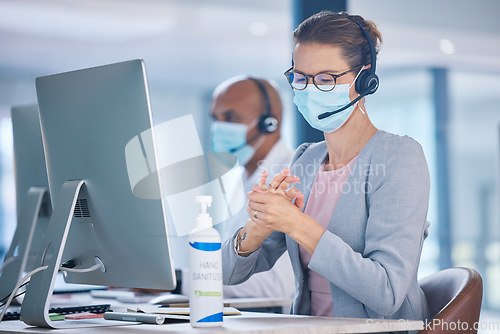Image of Covid, hand sanitizer and call center agent with mask cleaning hands, protecting or staying safe in customer support office. Receptionist, advisor or operator with computer preventing spread of virus