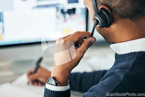 Image of Call center, customer service and agent assisting online customer with a headset and taking notes. Closeup of a male financial consultant or telemarketer working on a computer to consult clients.