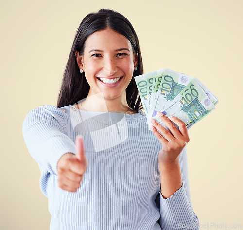 Image of Thumbs up, money and finance growth with cash, bank notes and currency after investment, savings and lottery win. Portrait of excited, happy or motivated woman approving wealth, budget or development