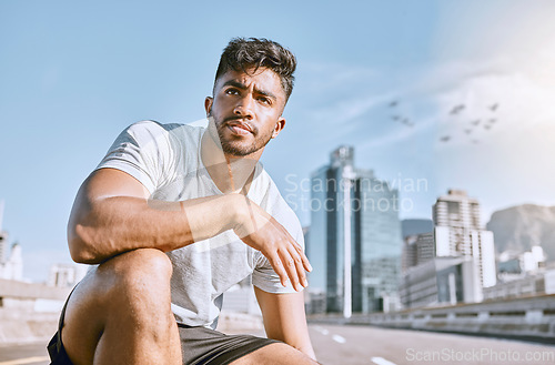 Image of Exhausted, runner and fitness athlete taking a break after a morning cardio workout at sunrise. Tired, urban male jogger resting after exercise and kneeling in the city after a training marathon.