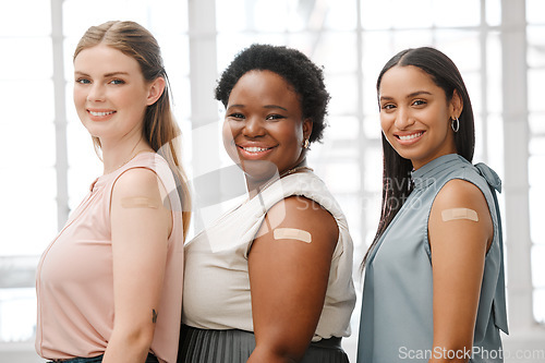 Image of Businesswoman with plaster after vaccination for business covid vaccine, safety and health protocol, protection against the virus. Smiling faces of female coworker standing together, showing support