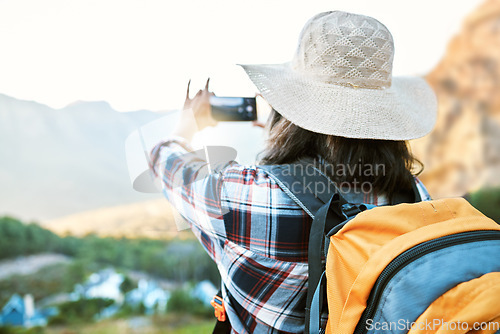 Image of Hiking woman taking photo on adventure with phone in nature, making memories on hike and enjoying the beautiful view in the countryside on vacation. Person taking pictures of the natural environment