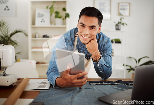 Image of Looking for fashion design ideas on tablet, planning creative clothing and working on website online while in a factory at work. Portrait of smiling designer, stylist or tailor at a shop for clothes