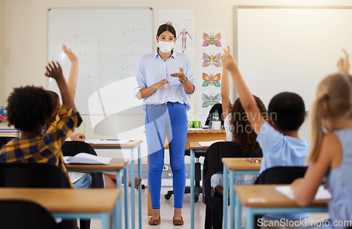 Image of Teacher asking questions to school kids who are eager, smart and clever for education in covid pandemic. Students raising hand to volunteer, join and answer educator in class lesson for learning