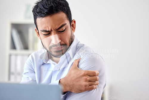 Image of Bad muscle pain in the arm, shoulder and body after an injury and ache while working in the office. Angry, upset and frustrated businessman with a painful strain, hurt and sore sitting at his desk