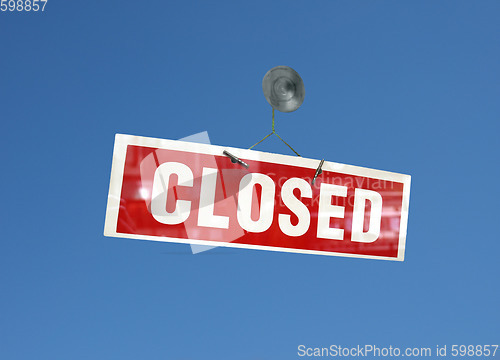 Image of Red closed sign over blue sky