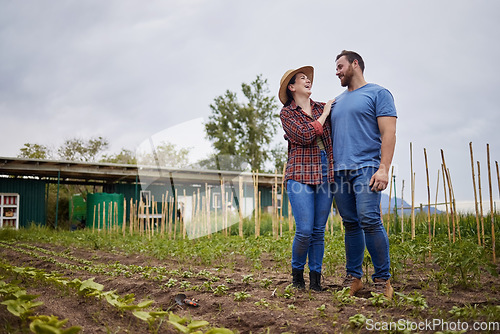 Image of Farmer couple happy about growing vegetable crops or plants in their organic or sustainable farm or garden. Affectionate nature activists enjoying the outdoors and having fun together