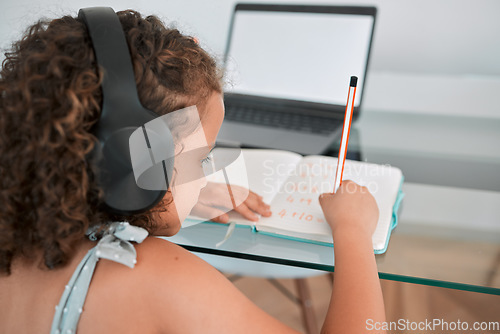 Image of Home, school and education of a girl writing, learning and working or study online on a laptop. Child, internet and student using technology for elearning at the house while listening to podcast.