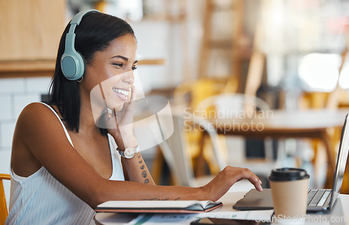 Image of Happy student relaxing, studying or searching online videos on her laptop at a coffee shop with free internet. Young woman at a cafe store listening to music, radio or podcast news entertainment