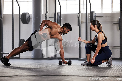 Image of Muscular, sports man with female gym instructor or fitness coach doing body building workout, push up plank exercise. Active male athlete weightlifting in wellness center with trainer for motivation.