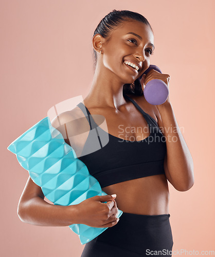 Image of Fitness, active and healthy woman holding a dumbell, foam roller and smile after sports training against studio background. Happy fit lady feel slim, happy and cheerful after gym, workout or exercise