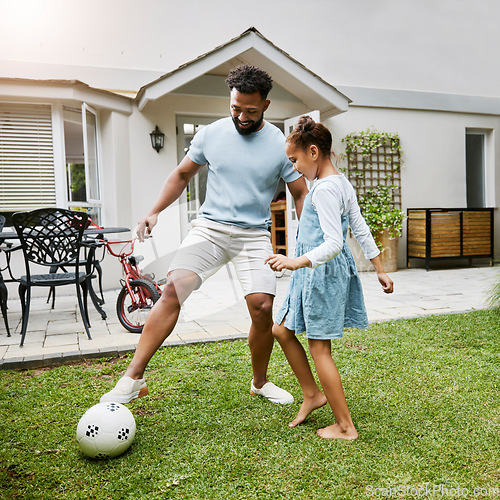 Image of Father and daughter bonding, playing with soccer ball in backyard at home, smiling and having fun. Happy parent being playful and enjoying family time with his child. Guy being active with his kid