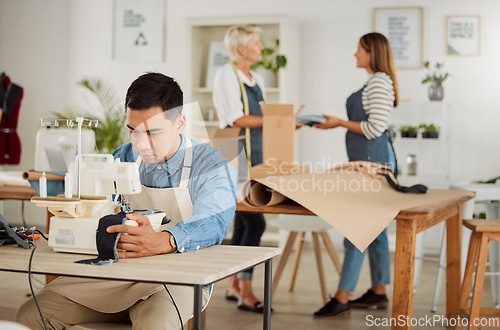 Image of Tailor, seamstress and creative designer working on a sewing machine in a design studio or workshop. Fashion, style and creativity with a young man knitting and stitching while making trendy clothing