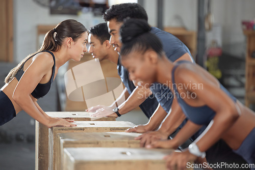 Image of Fitness, exercise and accountability group training and exercising together with wooden boxes at the gym. Diverse people and fit athletic friends looking serious and cross during a workout