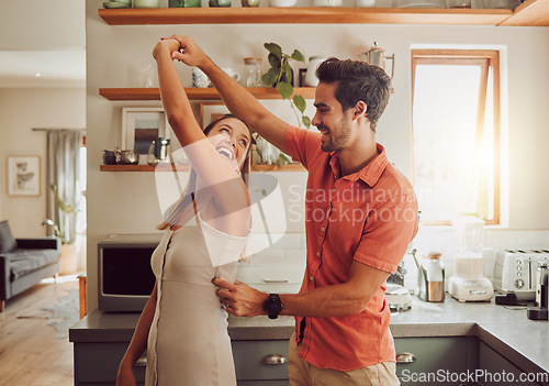 Image of Joyful, dancing and loving couple bonding and having fun in the kitchen together at home. Energetic, fun and active relationship sharing a dance and romantic moment while enjoying their anniversary.