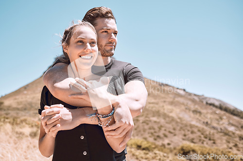 Image of Love, romance and dating with an affectionate young couple bonding while enjoying hiking, adventure and exploring together. Hugging, loving and dating with a man and woman looking at a nature view