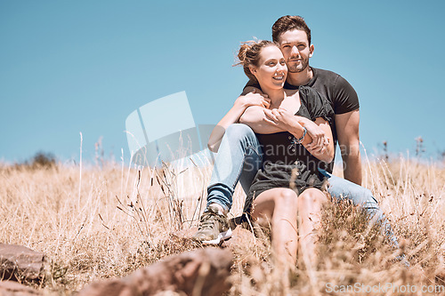 Image of Carefree, smiling and relaxed couple bonding, having fun and looking at the view while sitting on the grass in a nature park together. Loving, caring and romantic boyfriend and girlfriend hugging