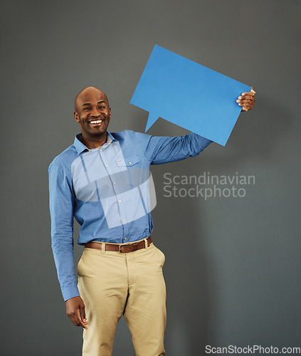 Image of Smiling, african american male voter holding a copyspace board sign on public opinion message. Casual and positive man holding a social media speech bubble or communication icon for news poll idea