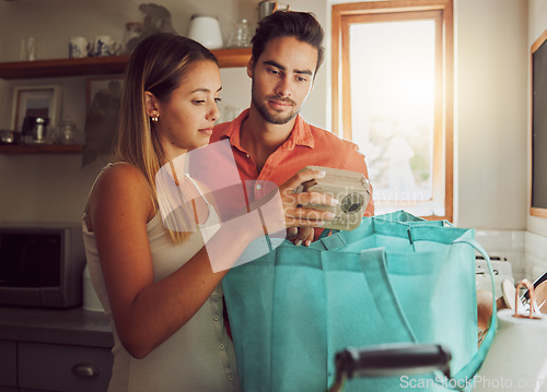 Image of Wrong order of grocery, food and kitchen products bought by a couple for home cook dinner or lunch. Unhappy male and female unpacking diet cooking supplies, ingredients or groceries from shopping bag