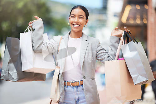 Image of Woman shopping, fashion and retail gift bags for customer buying stylish clothes and spending money on a city spree. Portrait smile, happy and fun lady with cool, trendy and sales presents from store