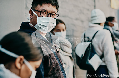 Image of Compliance, safety and covid travel restrictions with a group waiting in line to get a vaccine or booster shot. Corona face mask requirement in a crowd with diverse people waiting in to go abroad