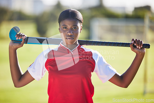 Image of Hockey player or coach holding stick ready for a competition or match on the sports ground or field. Portrait of a serious, fit and active black woman athlete at fitness training, exercise or workout