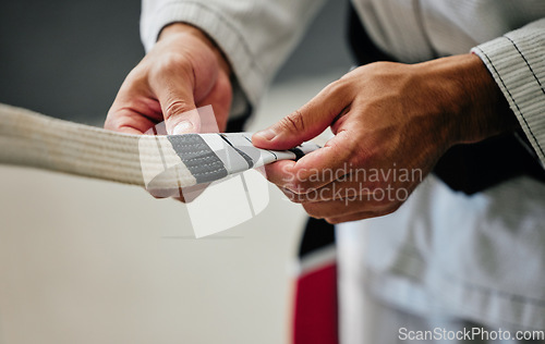 Image of Fitness, training and karate teacher hands prepare uniform for new student at a center or dojo. Martial arts sensei getting ready to lead a lesson on self defense, speed and physical endurance.