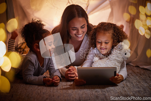 Image of Mother and children live streaming on an app using a tablet in a tent camping at home at night. Happy mom and kids watching online content or playing games with house wifi in the dark or evening