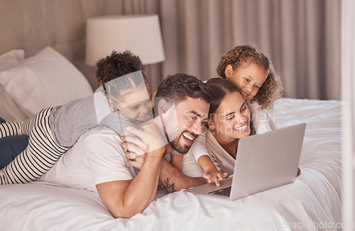 Image of Happy family streaming movies on laptop in bedroom for online entertainment to relax during the night at home. Smile, mother and father with girls, children or kids watching tv via internet together