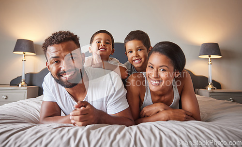 Image of Portrait of happy black family on a bed with children, carefree, relaxing and playing in a bedroom together. Young parents enjoying morning bonding, being playful and showing affection