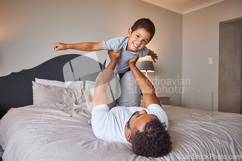 Image of Smile, love and happy father and son family time playing in bedroom bed lifting him like airplane or superhero. Loving dad, man or single parent bonding with cheerful kid in the morning at home.