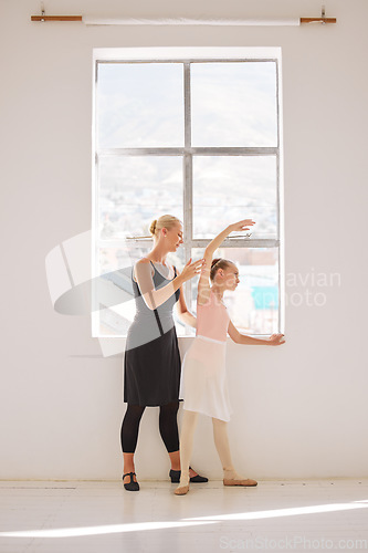 Image of Ballet student and teaching coach in dance class for kids art school and coaching or learning in professional studio by the window. Girl dancer training, stretching body with help, support of teacher