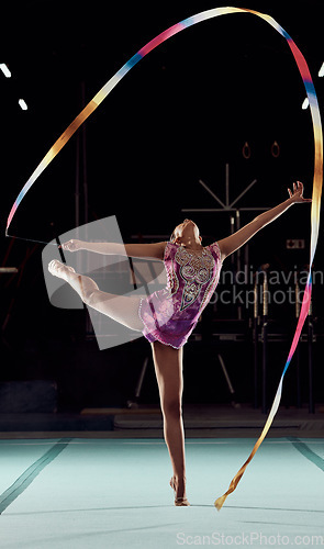 Image of Ribbon gymnastics, exercise and sports girl performing a routine in a professional gym arena. Fitness, flexibility and creative woman training balance, agility and strength for a competition show.