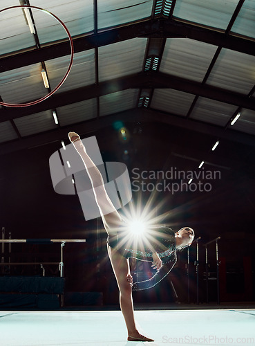 Image of Girl, art stage and body performance for gymnastic balance and competition practice studio. Acrobat sports and dancer woman with hula hoop ring stretching legs in front of flare light effect.