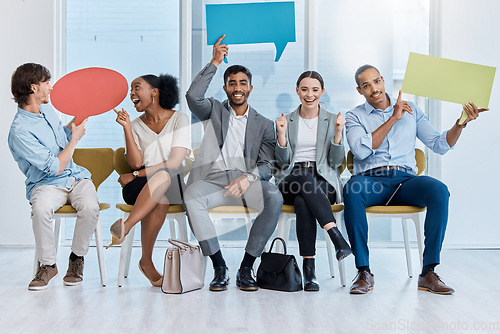 Image of Speech bubbles, voice and vote by business people happy and sitting in an office. A diverse team of employees holding empty comment signs or icons for social media company communication