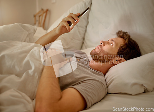 Image of Social media, mobile app and relax man with smartphone using the internet or online website content at night in his bedroom with home wifi. Serious insomnia person reading blog for sleep health tips