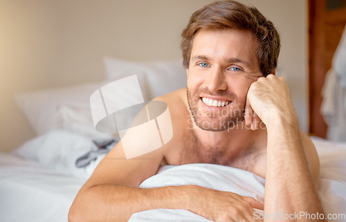 Image of Relax, home and bedroom with a young man lying in bed in the morning after waking up in his house. Resting, relaxation and time off with a male looking comfortable and happy with a smile on a weekend