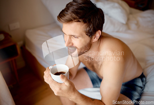 Image of Relax, bedroom and happy drinking tea or coffee man with smile sitting, smiling and thinking on bed in the morning. Portrait of male looking out window in home, house or apartment room on weekend.