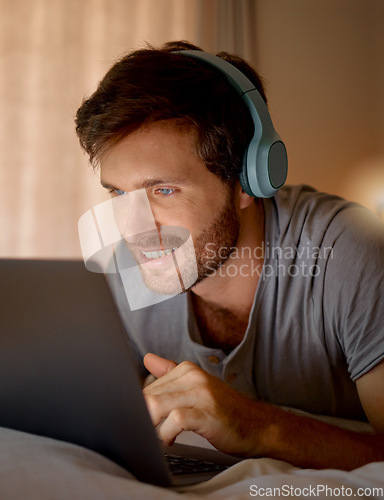 Image of Laptop, online tv and movie subscription with headphones late at night in his bedroom. Man with insomnia distracted with steaming internet to watch film, esports or enjoy gaming to relax at home