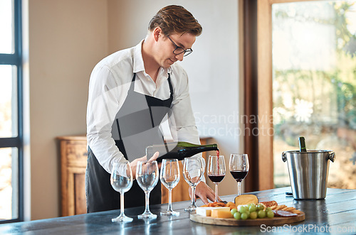 Image of Waiter, wine tasting, and bartender with glass at fine dining vineyard restaurant in countryside. Professional sommelier pouring quality and luxury alcohol drinks for winery expert masterclass.