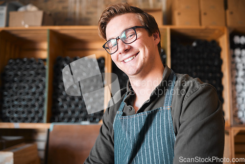 Image of Happy, smile and proud wine, warehouse or manufacturing worker wearing glasses in a cellar with a bottle collection on display. Winery manager or employee in the alcohol industry or distillery