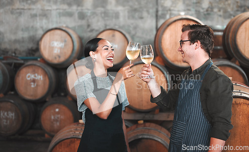 Image of Wine, glass and toast with a couple who drink alcohol in a cellar, distillery or winery estate together. Farming, collaboration and teamwork with a man and woman drinking and doing a cheers as a team