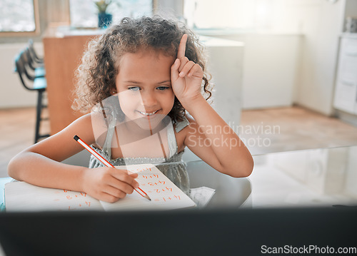 Image of Education, distance learning child in online class, maths lesson with a laptop, internet or wifi and at home. Smart, happy student raising hand on a video call while writing answer in a notebook