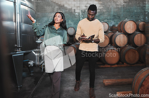 Image of Man, woman and winemaker giving tour to new employee learning logistics in a winery or wood barrel distillery. Business owner or ceo working at alcohol manufacturing and vineyard startup warehouse